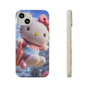 Op de afbeelding: Telefoonhoesje met een 3D-afbeelding van Hello Kitty. Het ontwerp toont Hello Kitty met een roze strik, rode tuinbroek en een rode koffer. De achtergrond is een vage stadsgezicht met een blauwe lucht.