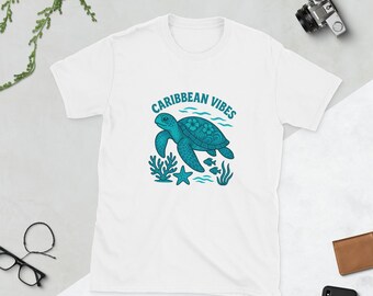 May include: White t-shirt featuring a turquoise sea turtle design, coral, and fish, with the words "Caribbean Vibes". The shirt is made of a soft material.