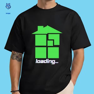 Peut inclure: T-shirt noir avec un motif de maison verte et le texte "loading...". Le motif de la maison est composé de carrés et d'un toit. Le texte blanc "loading..." est affiché sous le motif de la maison.