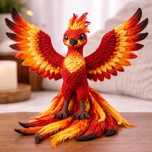 May include: A handcrafted, crochet phoenix sculpture with outstretched wings. The bird features vibrant red, orange, and yellow hues, with detailed feathering. The phoenix has a small, black beak and eyes, and is posed on a wooden surface.