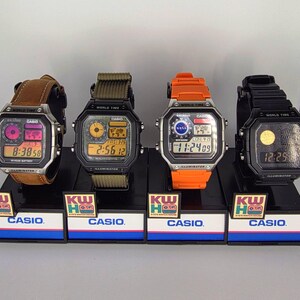 Puede incluir: Cuatro relojes digitales Casio en exhibici&oacute;n. Los relojes tienen varias correas de colores, incluyendo cuero marr&oacute;n, verde oliva, naranja y negro. Cada reloj muestra la hora y tiene una pantalla digital. La pantalla tambi&eacute;n muestra la palabra "ILLUMINATOR".