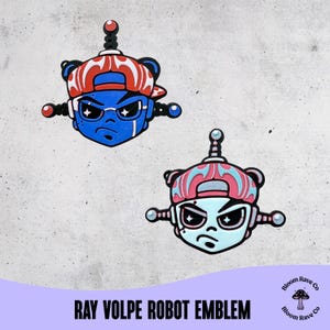 Peut inclure: Deux emblèmes de visage de robot bleu, portant des casquettes de baseball rouges et blanches et des lunettes. Les emblèmes ont une expression sévère et sont étiquetés "RAY VOLPE ROBOT EMBLEM".