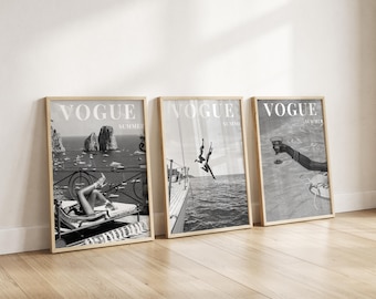 May include: A set of three black and white framed wall art prints, each featuring the word VOGUE and the word SUMMER. The prints display coastal scenes including a person lounging on a deck, a person jumping from a boat, and a hand holding a glass.