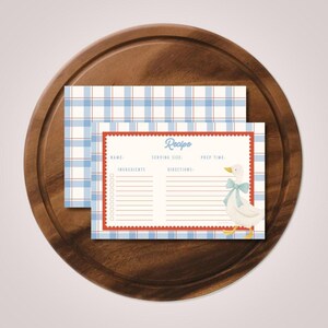 May include: A rectangular recipe card featuring a light blue and white plaid pattern with a red scalloped border. The card includes the text Recipe, Name, Serving Size, Prep Time, Ingredients, and Directions, with a white goose wearing a blue bow.
