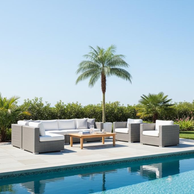Puede incluir: Juego de muebles de patio exterior de tejido gris claro. El conjunto incluye un sof&aacute; seccional, dos sillones y una mesa de centro rectangular de madera. Cojines blancos proporcionan comodidad al sentarse. Una palmera y una piscina en el fondo.