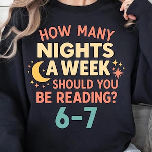 May include: Black sweatshirt with the text "HOW MANY NIGHTS A WEEK SHOULD YOU BE READING?" in orange and yellow. The text is accompanied by a crescent moon and stars graphic. The answer "6-7" is in teal.