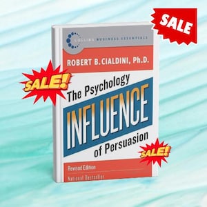 May include: A book titled "Influence: The Psychology of Persuasion" by Robert B. Cialdini, Ph.D. The book has a white cover with red, blue, and gray text. The words "SALE" are displayed in red starbursts.