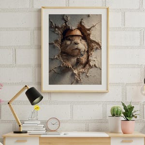 Puede incluir: Impresión enmarcada de una marmota con casco y llave inglesa, rompiendo una pared. La obra de arte tiene un marco de madera clara y se muestra sobre un escritorio con lámpara, reloj y plantas.