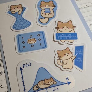 May include: A collection of six die-cut stickers featuring tan and white cats interacting with mathematical concepts. Designs include a cat in a blue grid, a cat holding a calculator, a cat with an integral equation, a matrix, a cat at a chalkboard, and a cat lying on a normal distribution curve labeled P(x) with mu and sigma notations.