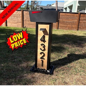 Buzón moderno, cuerpo revestido de cedro, diseño de marco grueso, luces solares, números flotantes, base de piedra con forma de nido.