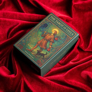 Pu&ograve; includere: Un mazzo di carte dei tarocchi intitolato "The Tarot of Leela" con una scatola verde con un'illustrazione di una figura con un alone, un cane e del testo. Il mazzo poggia su una superficie di velluto rosso.