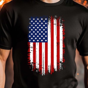 May include: Black t-shirt featuring a distressed American flag design. The flag graphic includes white stars on a blue background and red and white stripes. The words "DIGITAL PNG FILE" are at the bottom.