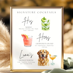 May include: A framed print with a gold border displays a cocktail menu. The menu features watercolor illustrations of cocktails: a Mojito, a Grapefruit Gin Fizz, and an Orange Martini. The text reads "Signature Cocktails".