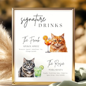 Puede incluir: Impresión enmarcada en oro con "Signature Drinks" y dos recetas de cócteles: "The Frank" (Aperol Spritz) y "The Rosie" (Margarita). Cada receta está ilustrada con un gato y una copa de cóctel. Fondo blanco.