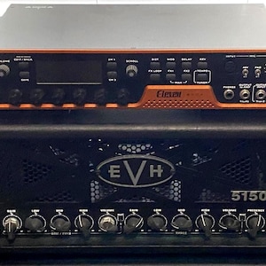 May include: Two-piece black and orange guitar amplifier. The top unit is orange with black controls and the word "Eleven" printed on it. The bottom unit is black with the letters "EVH" and the numbers "5150" printed on it.