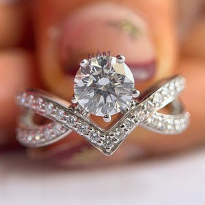 Elegant 1.10 CT round lab grown diamond engagement ring paired with a 14K gold criss cross wedding band. Featuring dazzling D-E color and VVS-VS clarity, this handcrafted sustainable ring is perfect for proposals, anniversaries, weddings, or heirloom gifts. Ethically made fine jewelry that blends modern style with timeless beauty. Ideal for eco-conscious brides seeking conflict-free diamond rings.