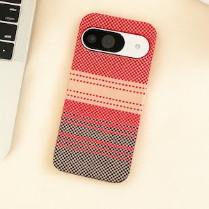 Può includere: Custodia per telefono a fantasia rossa, nera e beige. La custodia presenta un design geometrico e un ritaglio per la fotocamera. La custodia è progettata per uno smartphone.
