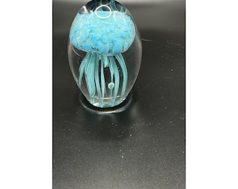 Pisapapeles de medusa de vidrio soplado a mano con diseño en tonos aguamarina y transparente.