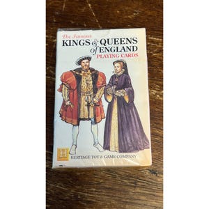 May include: A deck of playing cards titled "The Famous Kings & Queens of England." The box features illustrations of a king and queen in historical attire. The Heritage Toy & Game Company logo is visible.