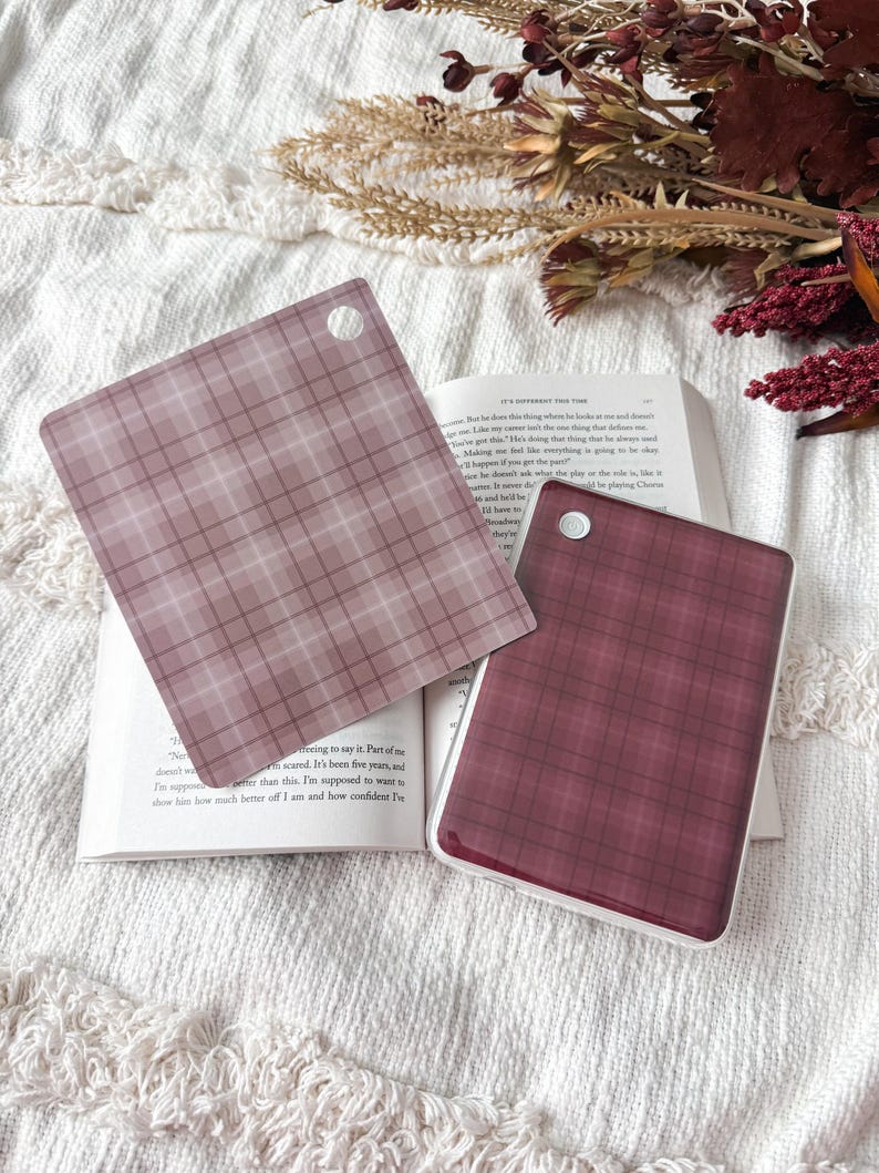 May include: Two square acrylic keychains featuring a plaid pattern. One keychain is a light mauve with a darker mauve grid, and the other is a deep burgundy with a dark grid. Each piece has a small circular hole in the corner for attachment.