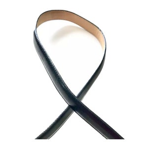 K&ouml;nnte beinhalten: Ein schwarzer Lederg&uuml;rtel mit glatter Oberfl&auml;che.