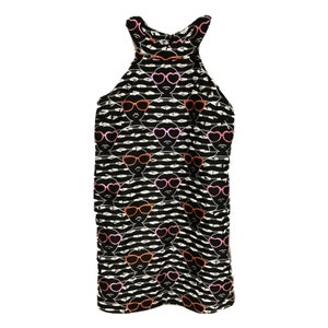 Puede incluir: Vestido negro sin mangas con un patr&oacute;n de rayas blancas y negras. El patr&oacute;n presenta un dise&ntilde;o repetido de una cara con gafas de sol de coraz&oacute;n rosa.