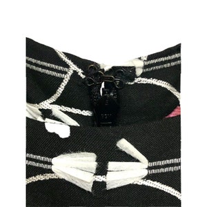 Puede incluir: Tela estampada en blanco y negro con una cremallera negra y un ribete blanco. La tela tiene un dise&ntilde;o geom&eacute;trico con l&iacute;neas blancas y c&iacute;rculos blancos.