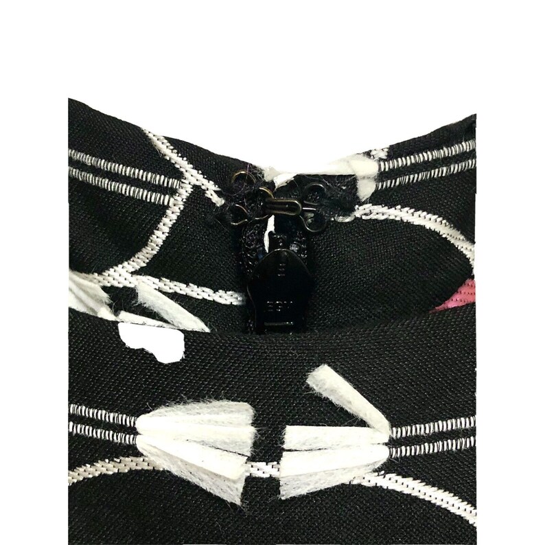 Puede incluir: Tela estampada en blanco y negro con una cremallera negra y un ribete blanco. La tela tiene un dise&ntilde;o geom&eacute;trico con l&iacute;neas blancas y c&iacute;rculos blancos.