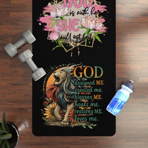 Puede incluir: Esterilla de yoga negra con gráficos florales y de león, y el texto "GOD is with her, SHE will not fail" y "GOD designed ME, created me, blesses ME, heals me, restores ME, loves me." También hay dos pesas grises y una botella de agua azul.