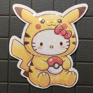 Pode incluir: Um autocolante hologr&aacute;fico com uma combina&ccedil;&atilde;o de personagens de desenhos animados. O design combina elementos de Pikachu e Hello Kitty, com as cores amarelo e castanho de Pikachu e o rosto e la&ccedil;o vermelho de Hello Kitty. A personagem segura uma Pok&eacute; Bola.