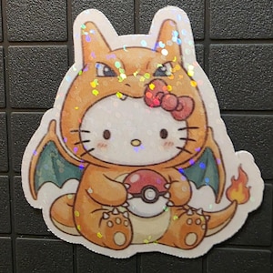 Pode incluir: Um autocolante hologr&aacute;fico com uma mistura de personagens de desenhos animados. O design combina a apar&ecirc;ncia de Hello Kitty com uma fantasia de Charizard, segurando uma Pok&eacute; Bola. O autocolante tem detalhes em laranja, vermelho e verde, com um la&ccedil;o vermelho.