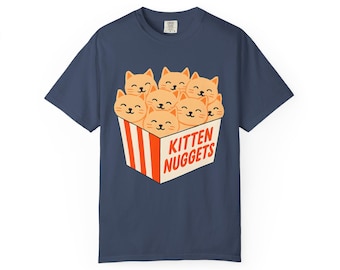 Puede incluir: Camiseta azul marino con un diseño de caras de gatitos en una caja de comida rápida con el texto "Kitten Nuggets". La camiseta es de estilo casual, adecuada para el uso diario.