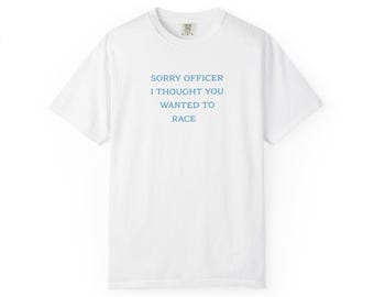 May include: White t-shirt with the text "SORRY OFFICER I THOUGHT YOU WANTED TO RACE" in blue. The shirt has a crew neck and short sleeves. The text is centered on the front of the shirt.