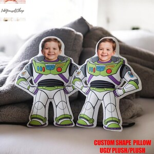 Two custom-shaped pillows with images of smiling children on them, placed on a bed.
