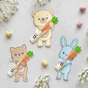 May include: Three cartoon animal cutouts: a bear, a cat, and a bunny, each holding a carrot-shaped candy with text. The bear is light yellow, the cat is brown, and the bunny is light blue. Easter eggs and flowers are scattered around.