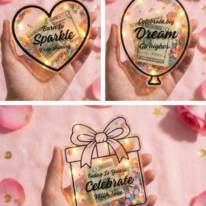 K&ouml;nnte beinhalten: Drei transparente, dekorative Geldhalter in Herz-, Ballon- und Geschenkboxform. Jedes enth&auml;lt einen US-Dollar-Schein, Konfetti und Lichterketten. Der Text lautet "Born to Sparkle", "Celebrate big Dream" und "Today Is Yours Celebrate With love".