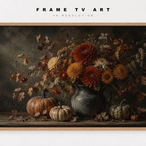 May include: A digital artwork titled FRAME TV ART 4K RESOLUTION featuring a still life of a dark gray pitcher filled with orange, yellow, and red chrysanthemums, surrounded by scattered autumn leaves and three pumpkins on a wooden surface.
