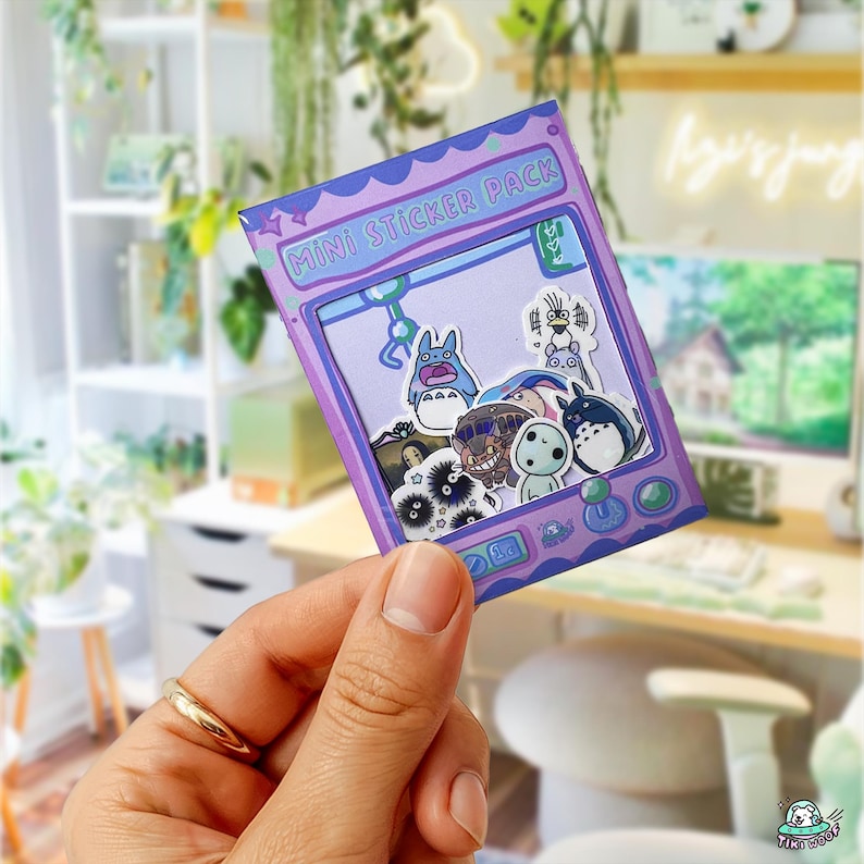 May include: A purple "Mini Sticker Pack" with anime character stickers. The pack has a retro arcade game design with a light purple border and the text "Mini Sticker Pack" in white.