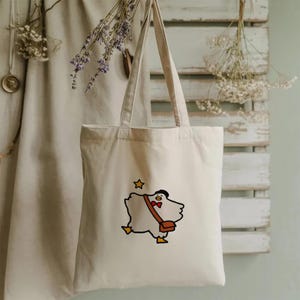 フラインググースの刺繍が施されたコットンキャンバストートバッグ、クロスボディサッチェル、星のディテール、再利用可能なショッパー、かわいい動物のイラストのギフト