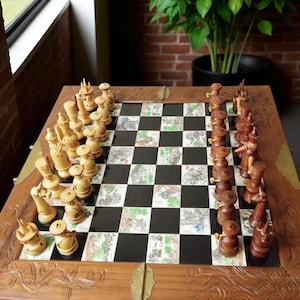 May include: A wooden chess set with intricately carved pieces in light and dark tones. The chessboard features black and white squares with decorative illustrations. The set is displayed on a detailed wooden table.