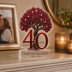 May include: A clear acrylic anniversary plaque featuring a sculpted tree with deep red leaves and small gold hearts. The number 40 is prominently displayed with the names Michael and Emily. The base reads HAPPY 40TH ANNIVERSARY 1986 - 2026.
