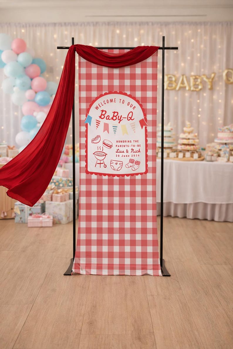 May include: A red and white chequered banner with the text "WELCOME TO OUR BaBy-Q" is displayed at a baby shower. The banner includes illustrations of food and baby items. A red fabric drapes from the top.