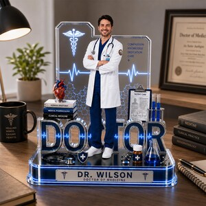 Puede incluir: Una decoraci&oacute;n de tem&aacute;tica m&eacute;dica con una figura de m&eacute;dico, libros y equipo de laboratorio. La base dice "DR. WILSON DOCTOR OF MEDICINE". La palabra "DOCTOR" es prominente, junto con un s&iacute;mbolo de caduceo. La pantalla est&aacute; iluminada con luces azules.