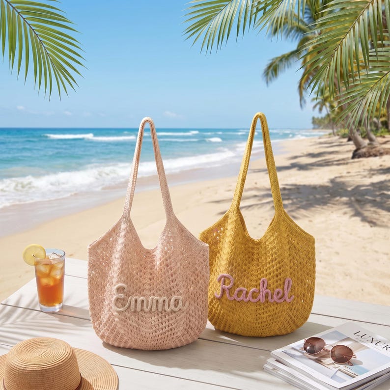 May include: Two open-weave tote bags, one blush pink and one golden yellow, sit on a white table. The pink bag has "Emma" stitched on it, and the yellow bag has "Rachel". The bags have long handles, perfect for carrying beach essentials.