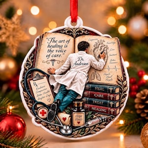 Puede incluir: Un adorno redondo con un médico con bata blanca escribiendo en un libro abierto con el texto The art of healing is the voice of care. Incluye un estetoscopio, un recetario, un frasco de medicina con la etiqueta Hope Heals y libros.