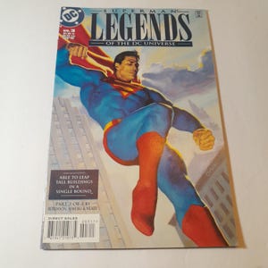 May include: Superman Legends of the DC Universe comic book cover featuring a red, blue, and yellow Superman flying over a city. The cover text reads "Superman Legends of the DC Universe" and "No. 3".