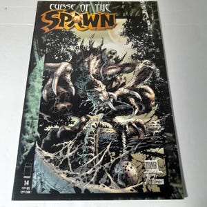 Puede incluir: Portada de cómic para "Curse of the Spawn" número 14. La portada presenta una ilustración detallada de una criatura monstruosa con garras afiladas y una expresión amenazante, sobre un fondo oscuro y parecido a un bosque. El título está en una fuente estilizada.