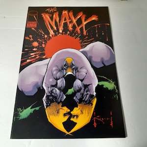 Puede incluir: Portada de cómic de "The Maxx" #1. La portada presenta una figura grande y musculosa con una máscara amarilla y negra y una gran mano con forma de garra. El fondo es negro con un sol rojo y el título "The Maxx".