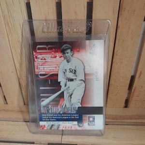 May include: A baseball trading card of Rick Ferrell in a protective case. The card is labelled "All-Star Moments" and commemorates the first All-Star Game. The card has the text "SOX" on the player's uniform. The card is numbered 900/900.