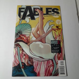 May include: A comic book cover for "Fables" features a woman reclining in a flower, with the title in large letters. The artwork is colorful, with a yellow background and a Vertigo Comics logo.